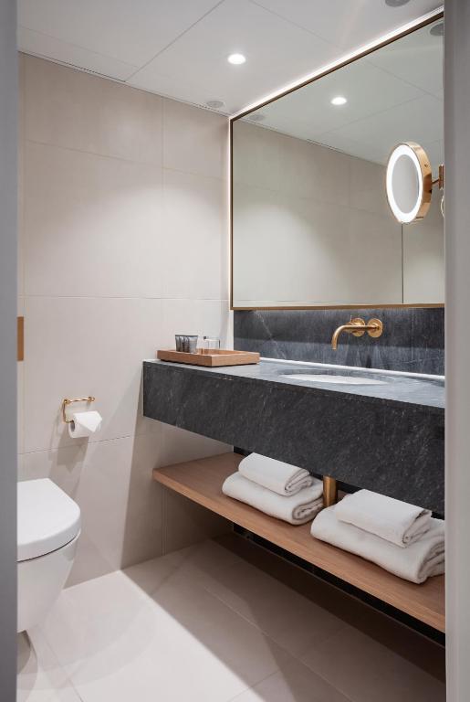 a bathroom with a sink and a toilet and a mirror at Copenhagen Admiral Hotel in Copenhagen
