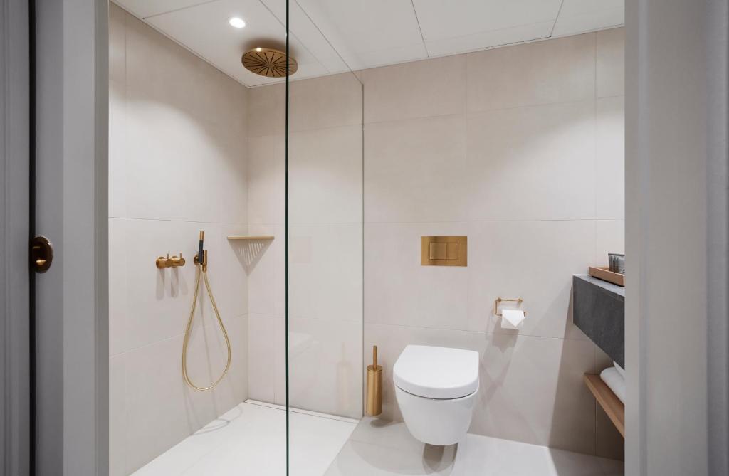 a bathroom with a toilet and a glass shower at Copenhagen Admiral Hotel in Copenhagen