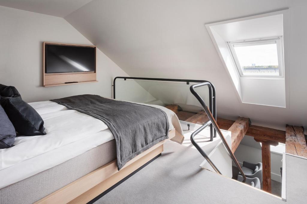 a bedroom with a bed and a tv on the wall at Copenhagen Admiral Hotel in Copenhagen