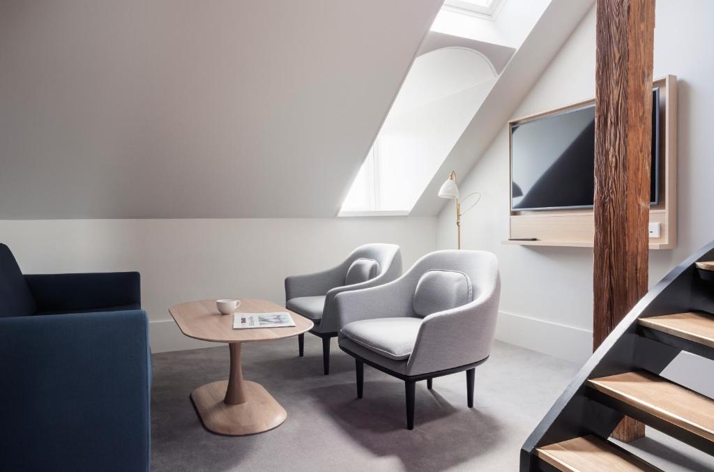 a living room with two chairs and a tv at Copenhagen Admiral Hotel in Copenhagen