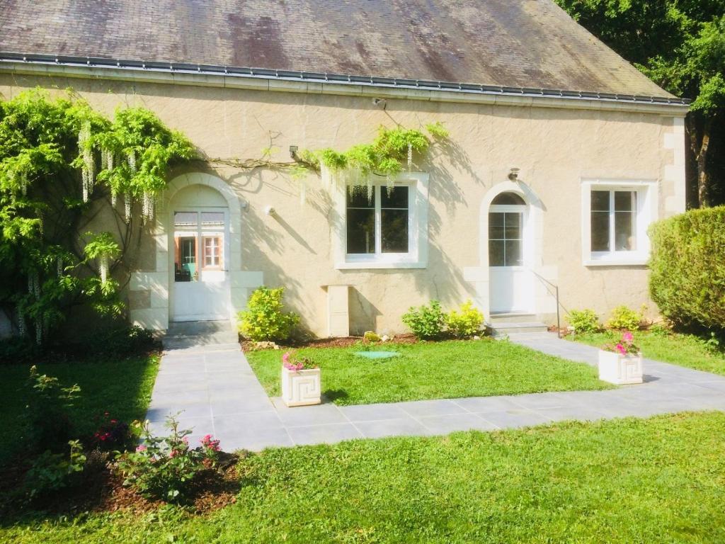 a house with a grass yard and a sidewalk at Les Moulins de Requeugne in Tauxigny