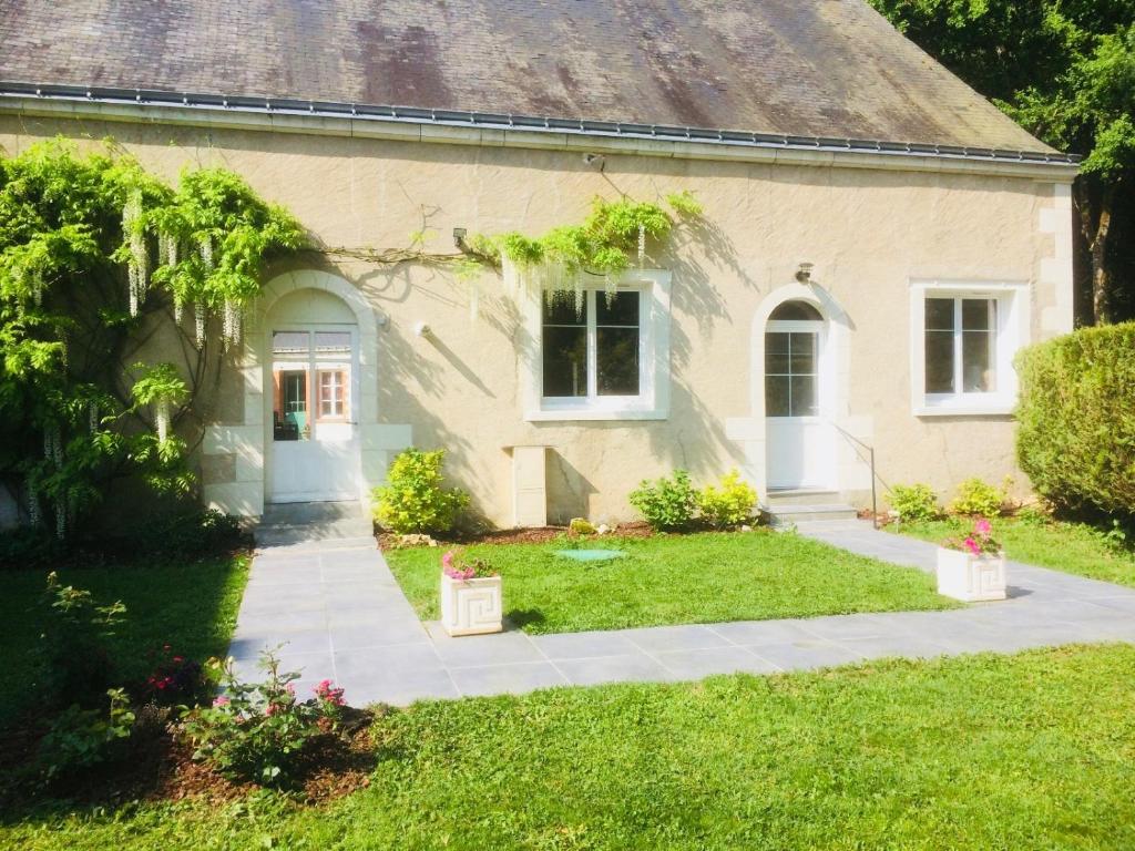 ein Haus mit einem Rasenplatz und einem Gehweg in der Unterkunft Les Moulins de Requeugne in Tauxigny