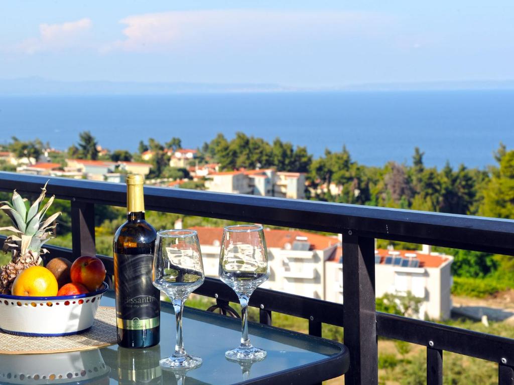 un tavolo con due bicchieri e una bottiglia di vino di Seaview Studios Kriopigi a Kriopigi