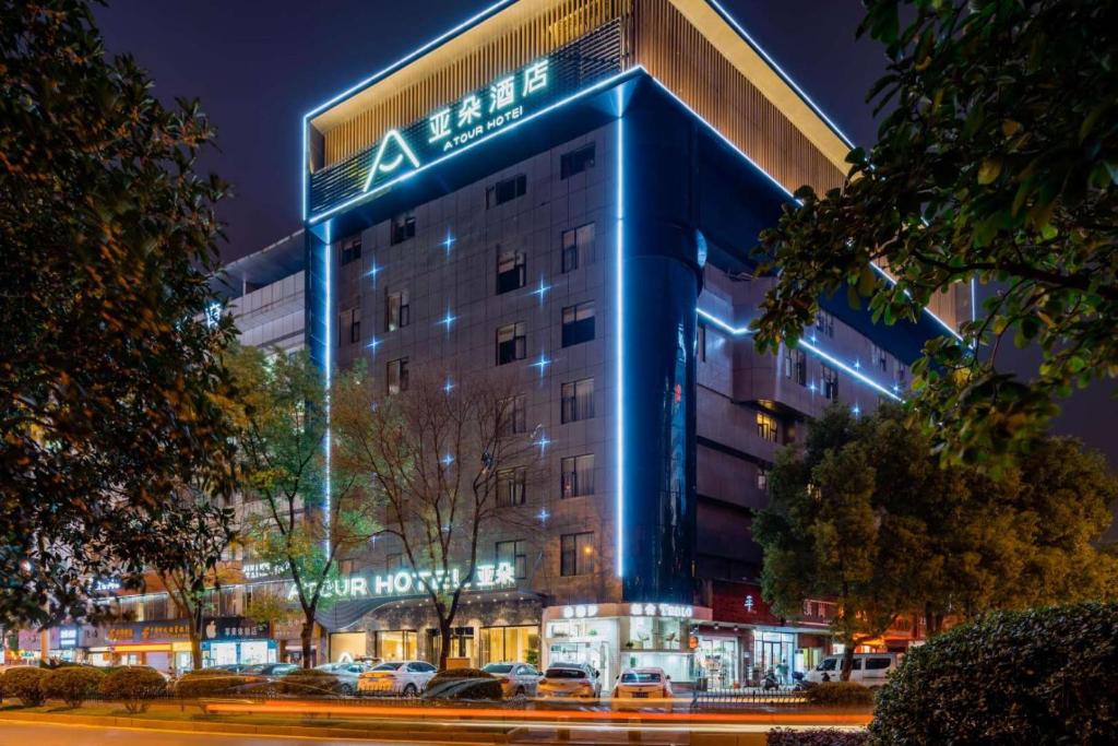 un edificio con una señal azul en el costado. en Atour Hotel Shangrao Central Square en Shangrao