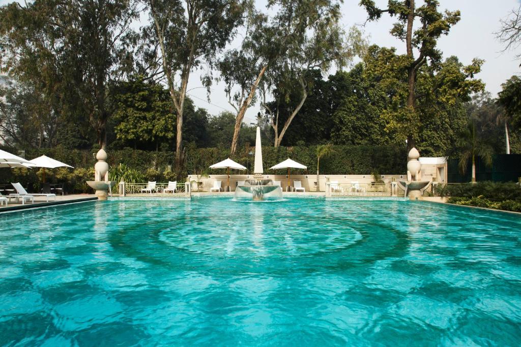 a swimming pool with a pool table and chairs at The Imperial, New Delhi in New Delhi
