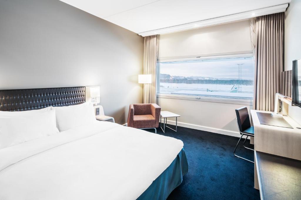 a hotel room with a bed and a window at Radisson Blu Hotel, Trondheim Airport in Stjoerdal