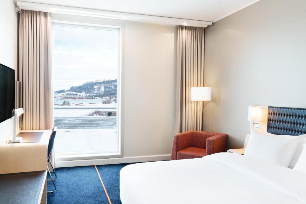 a hotel room with a bed and a window at Radisson Blu Hotel, Trondheim Airport in Stjoerdal