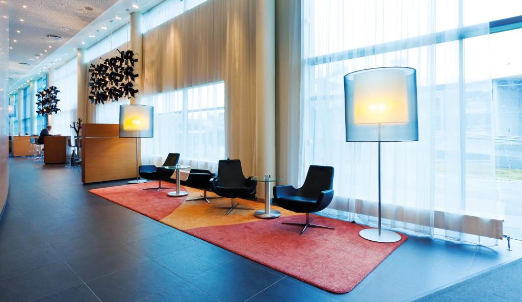 a lobby with chairs and a table in a building at Radisson Blu Hotel, Trondheim Airport in Stjoerdal