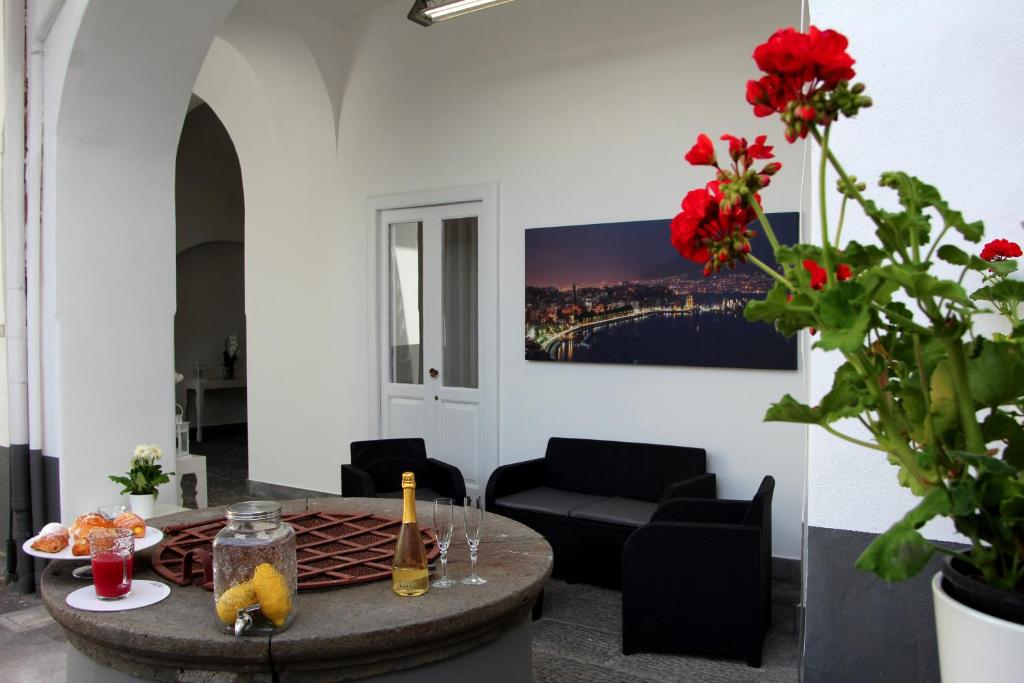 ein Wohnzimmer mit einem Tisch und roten Blumen in der Unterkunft Giardino Del Vesuvio, Pompei in Terzigno