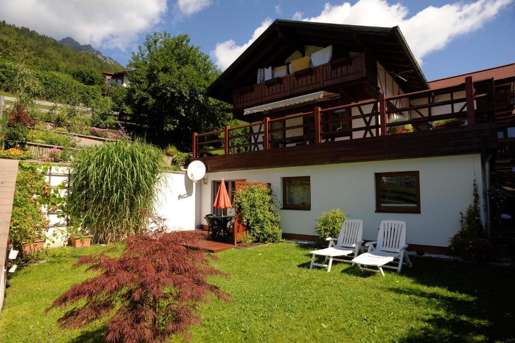 ein Haus mit zwei Stühlen im Hof in der Unterkunft Ferienwohnung Arndt in Fulpmes