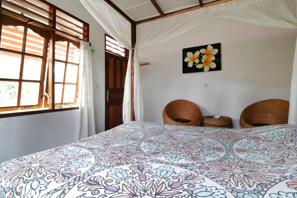 a bedroom with a bed with a flower on the wall at Bagus Bay Homestay in Tuktuk Siadong