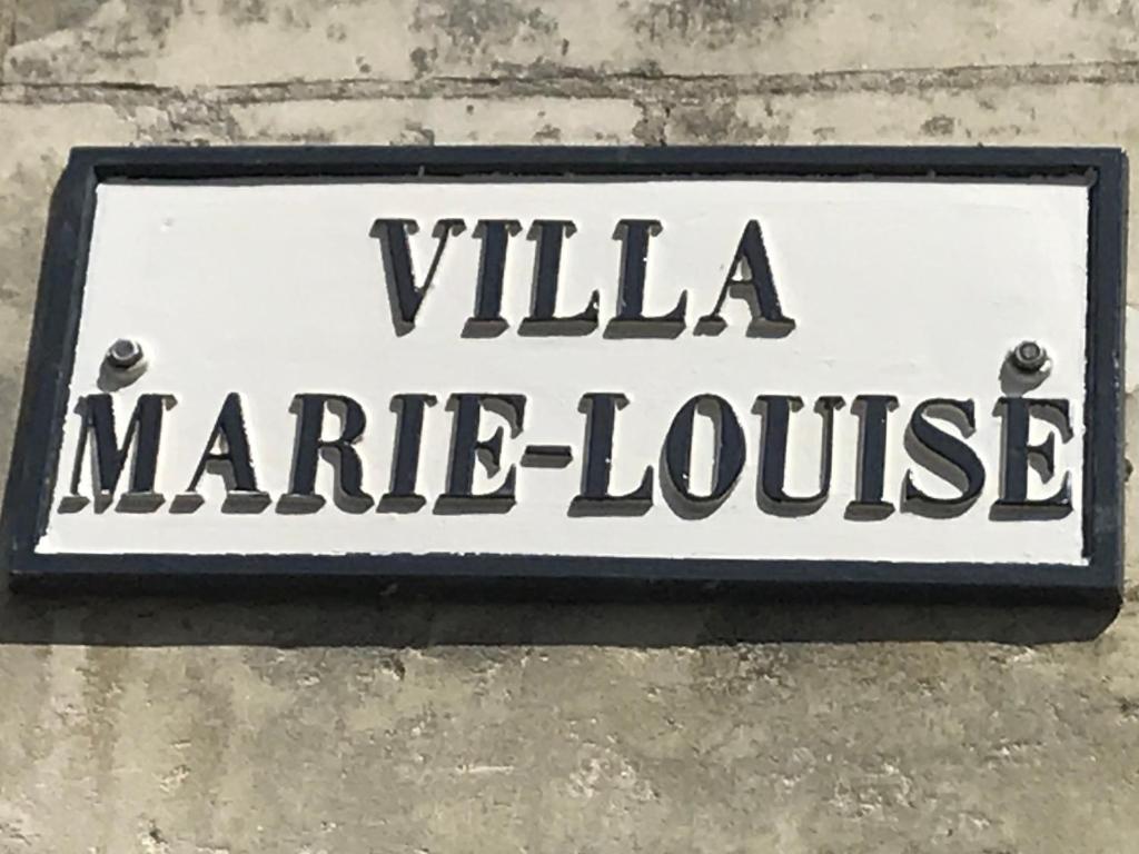 una señal para una casa de mercado en una pared en Chambre Troglodytique Villa Marie Louise en Rochecorbon