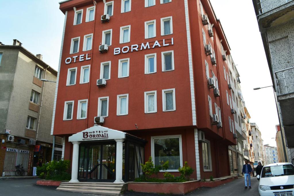 a red building with a sign on the side of it at Bormali Hotel in Corlu