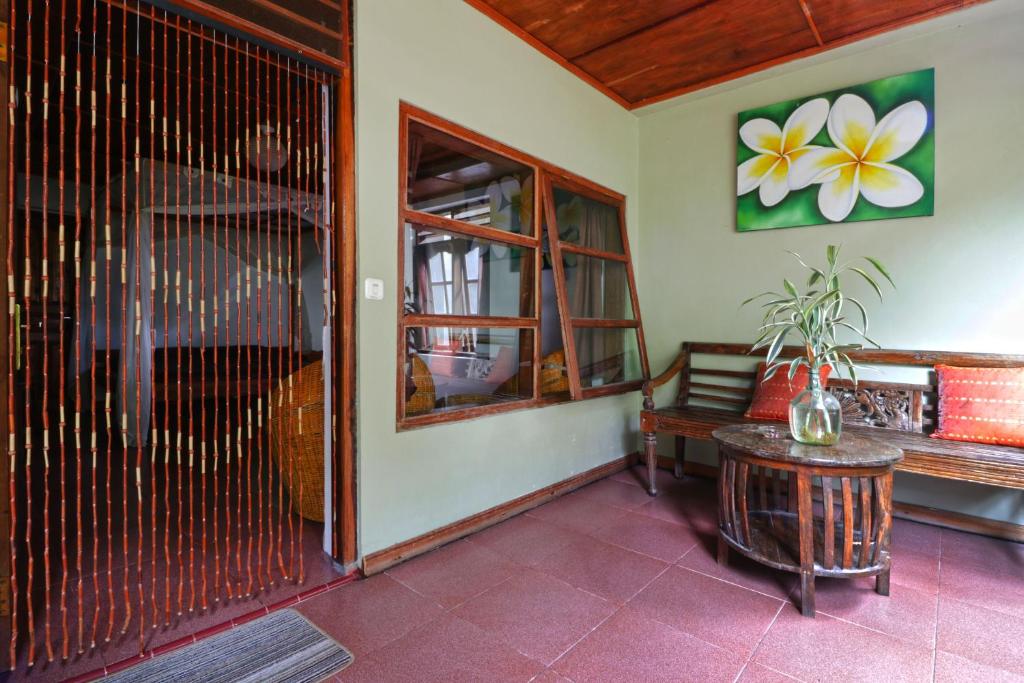 a room with a bench and a bird cage at Bagus Bay Homestay in Tuktuk Siadong