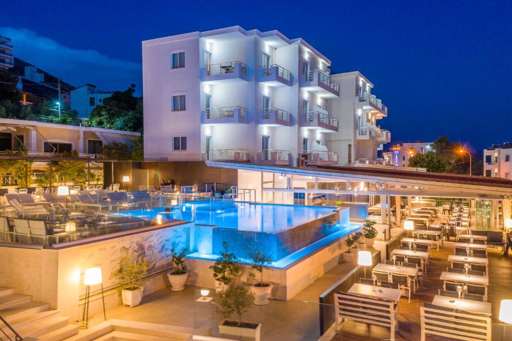 un hotel con piscina por la noche en Hotel Agimi, en Sarandë