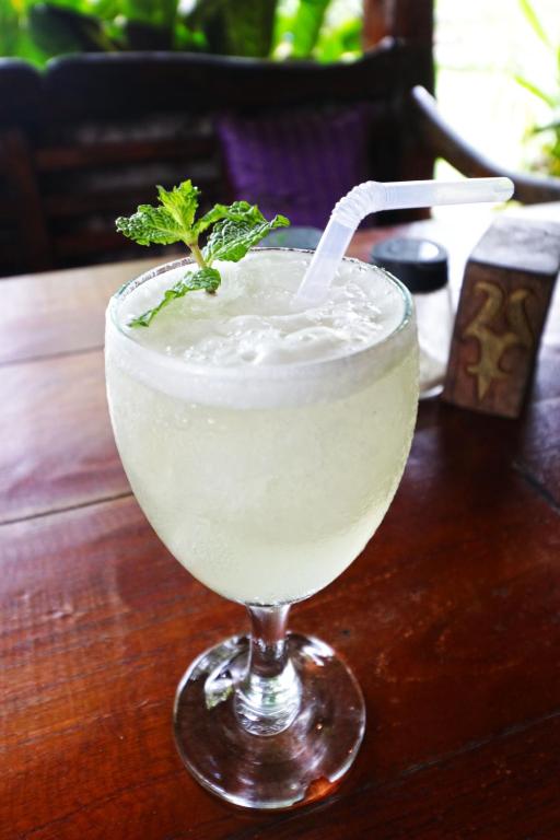 a drink in a glass on a wooden table at Bagus Bay Homestay in Tuktuk Siadong