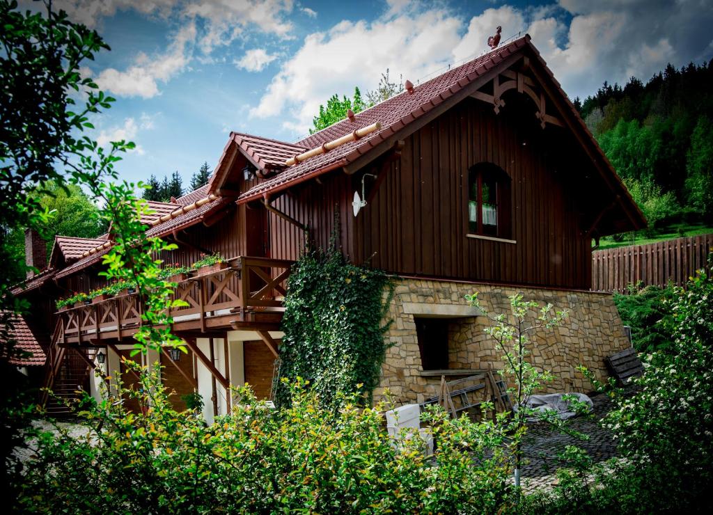 a house with a brown roof and some trees at Apartamenty Romanowka in Raszów