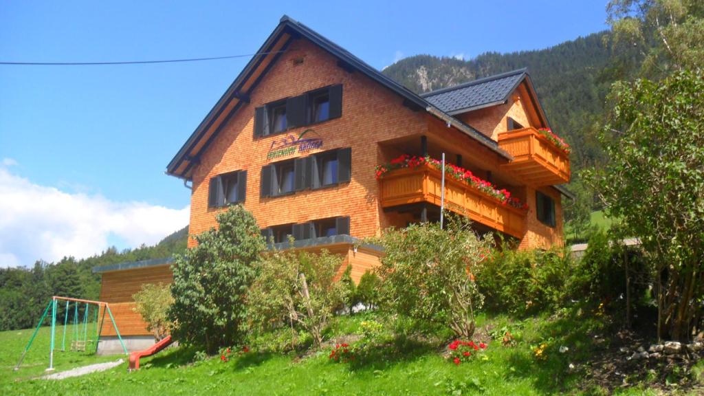 a large brick building with windows on a hill at Haus Brügga in Brand