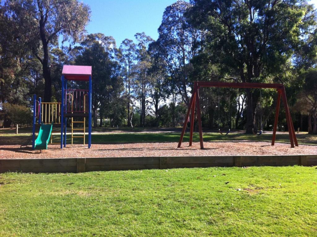einen Spielplatz mit zwei Schaukeln in einem Park in der Unterkunft Mallacoota's Shady Gully Caravan Park in Mallacoota