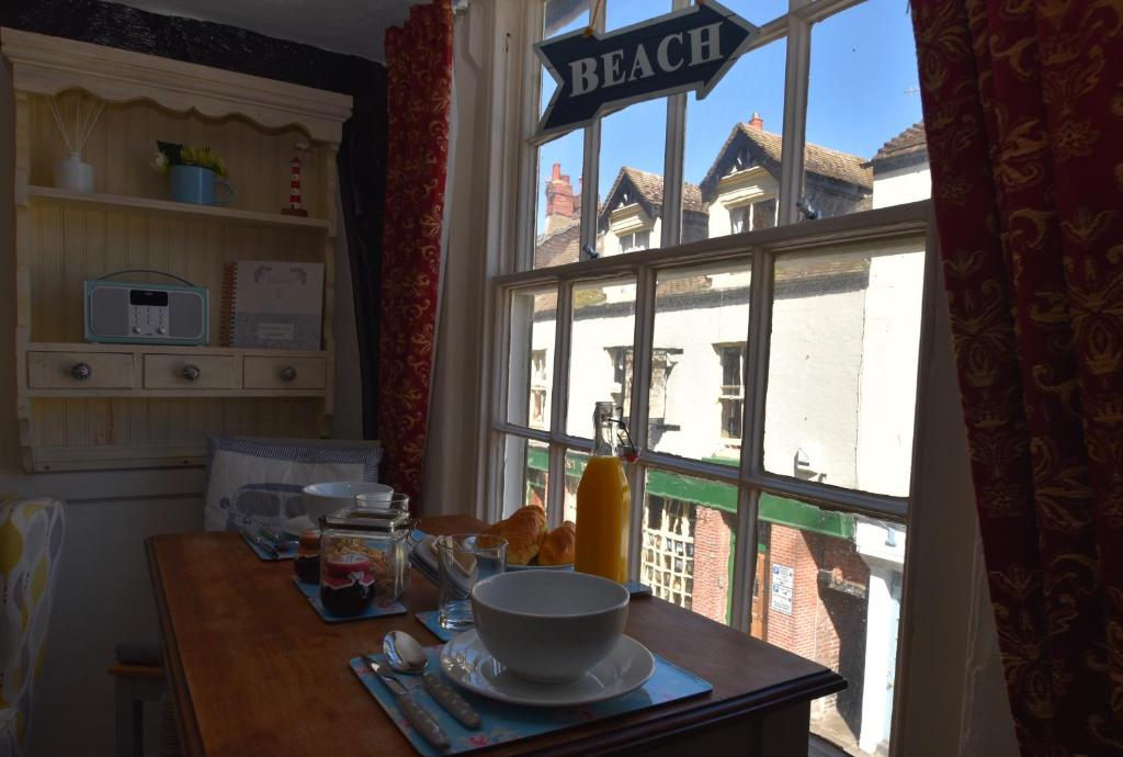 a table with a plate of food in front of a window at Old Town Bolthole in Hastings