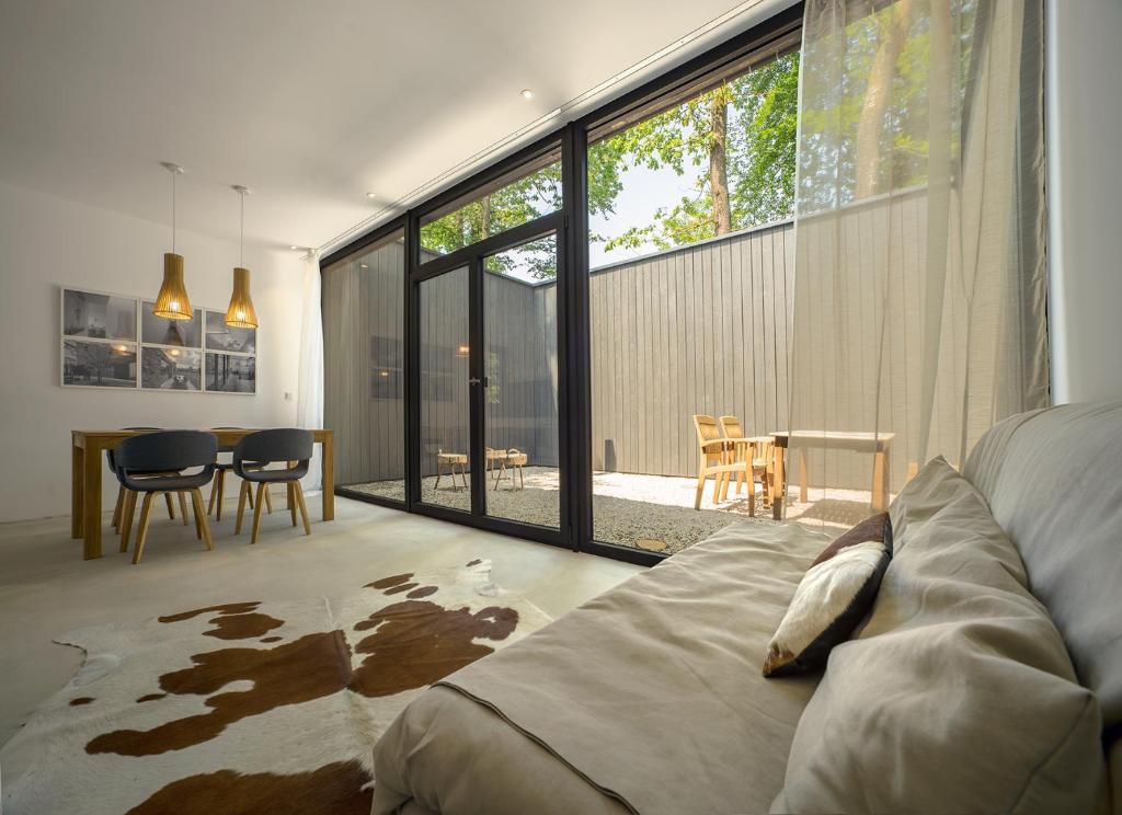 a bedroom with a couch and a dining room with a table at Architektur Ferienhaus Eifel SUITE17 in Bad Münstereifel