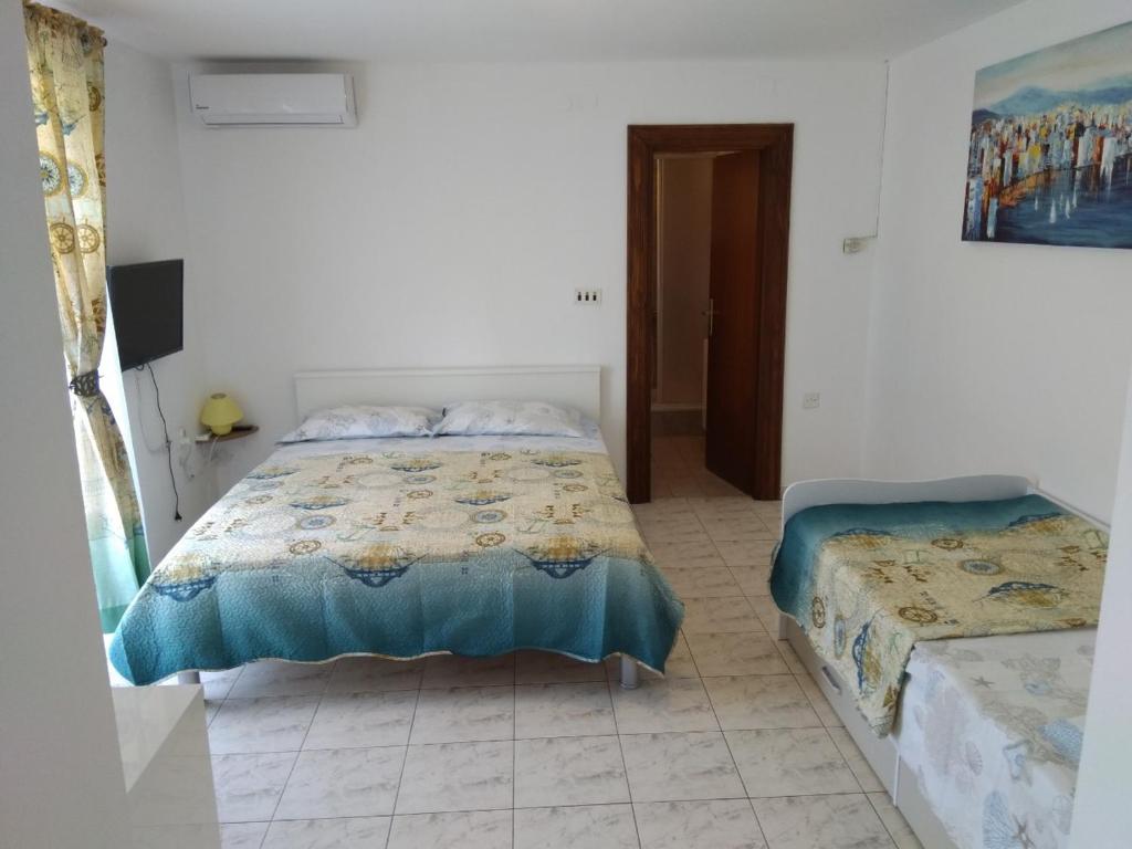 a white room with two beds and a doorway at Apartments Vitae in Pula