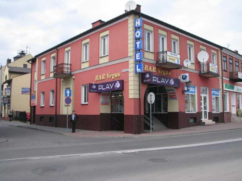 a man standing in front of a building on a street at Usługi Hotelarskie Las Vegas in Międzyrzec Podlaski