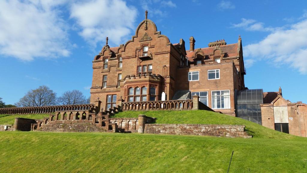 a large building with a clock on the top of it at Adamton Country House Hotel in Prestwick