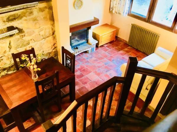 Una sala de estar con una mesa y una chimenea. en Apartamentos Torre Villar, en Villar de Vildas