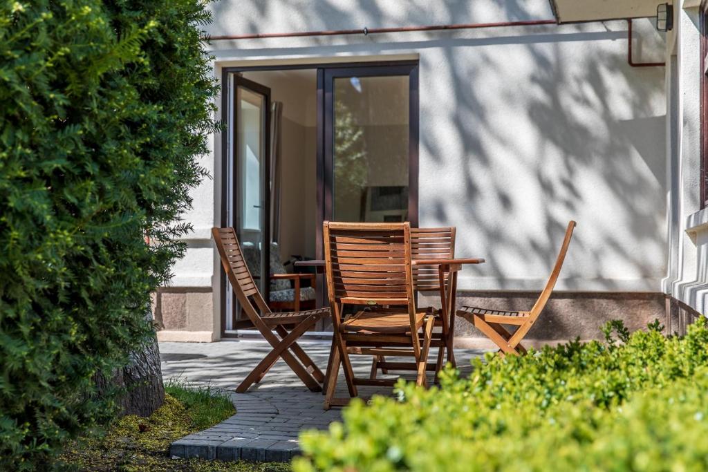 deux chaises et une table sur une terrasse dans l'établissement Vila prie jūros, à Palanga