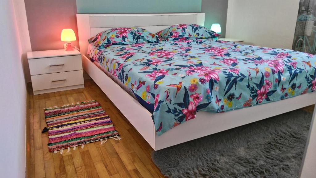 sypialnia z łóżkiem z kwiatową narzutą i dywanem w obiekcie Vacation House Bimba - Pomer w mieście Pomer