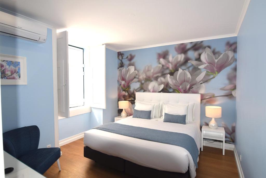 a bedroom with a bed and a painting on the wall at Lx Flowers Apartments in Lisbon