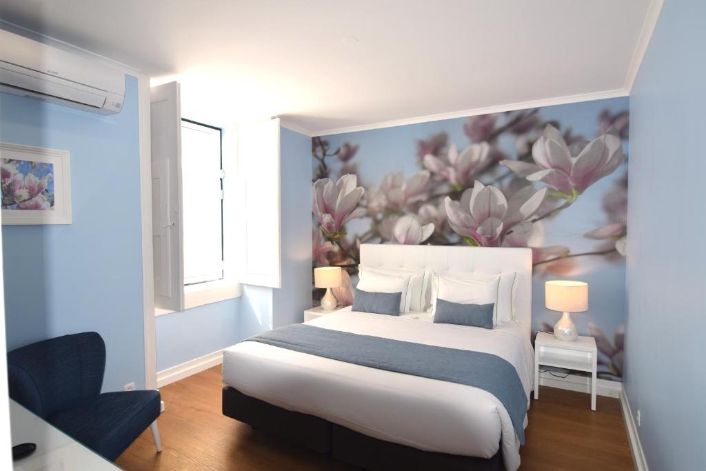 a bedroom with a bed with a flower mural on the wall at Lx Flowers Apartments in Lisbon