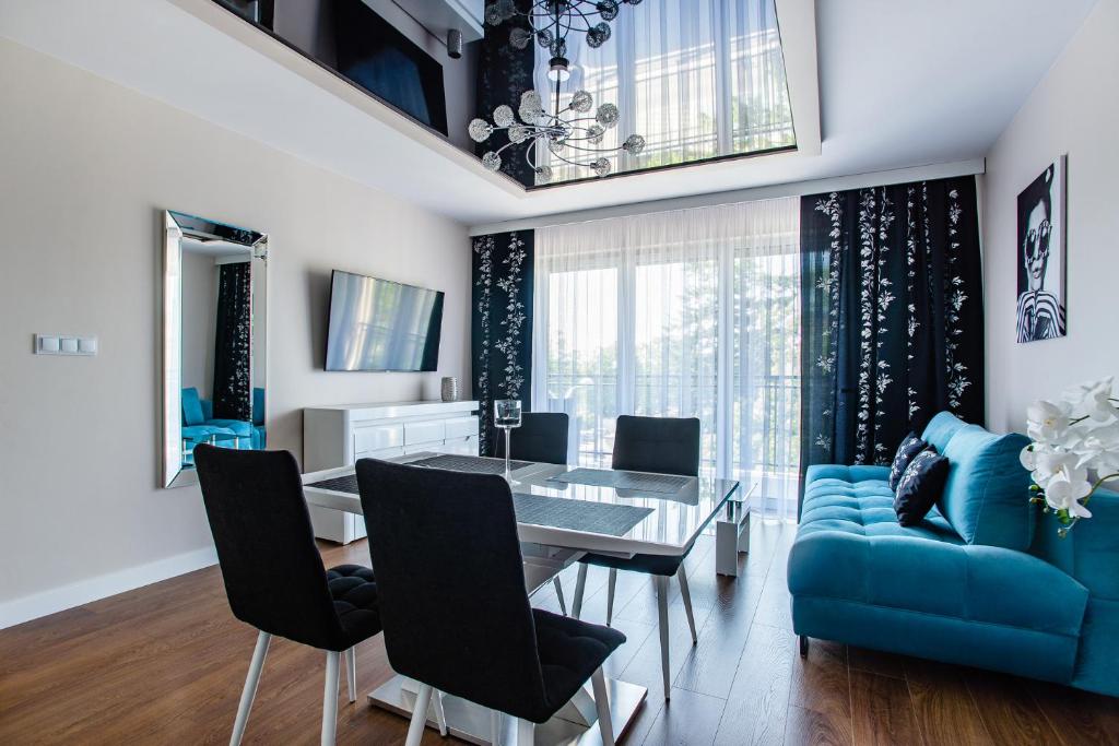 jadalnia ze stołem i niebieską kanapą w obiekcie Apartamenty Bristol w Kielcach