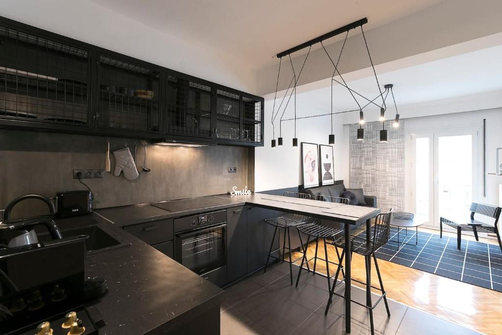een keuken met zwarte kasten en een aanrecht bij #FLH - Traveller`s Nest in Thessaloniki