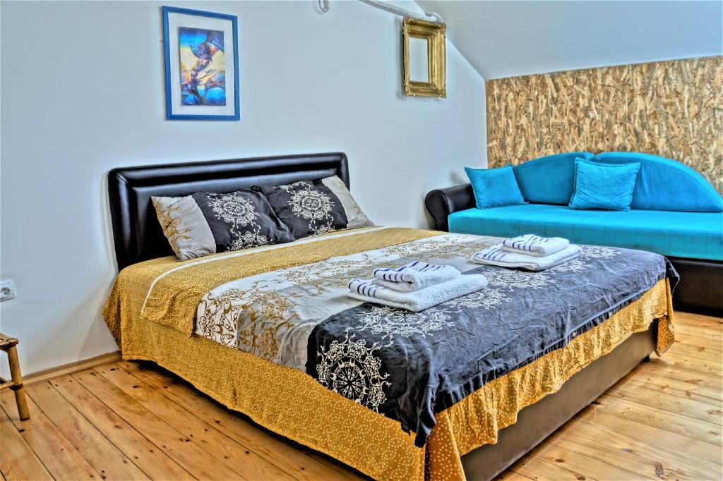 a bedroom with a bed and a blue couch at Central Apartment in Nikšić