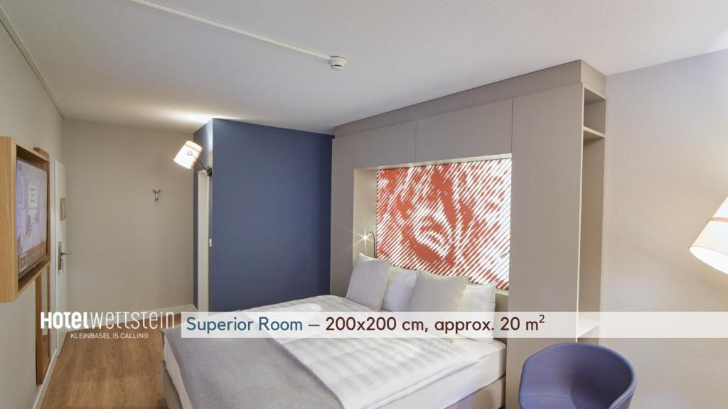 a bedroom with a bed with a window and a blue wall at Hotel Wettstein in Basel
