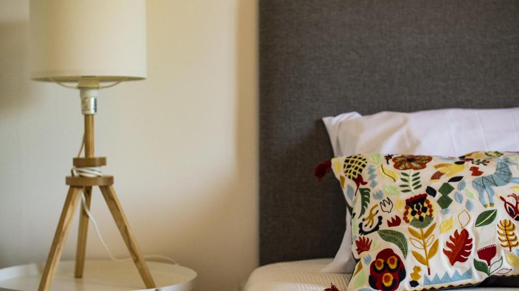 a lamp sitting on a table next to a pillow at Pine House - Faro Airport, Beach and City Center in Faro
