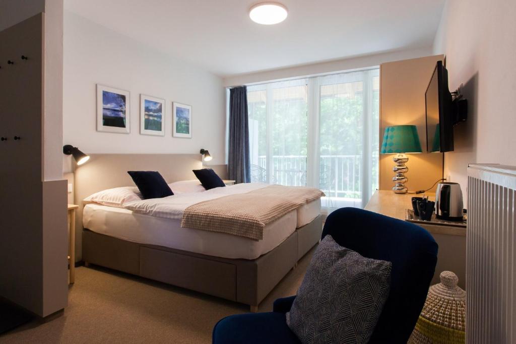 ein Schlafzimmer mit einem Bett und einem großen Fenster in der Unterkunft Resort-Restaurant Stilec in Kamenný Újezd