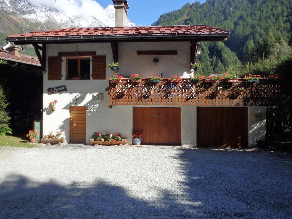 a house with a balcony with flowers on it at Chalets Pyrene Mont-Blanc in Chamonix-Mont-Blanc