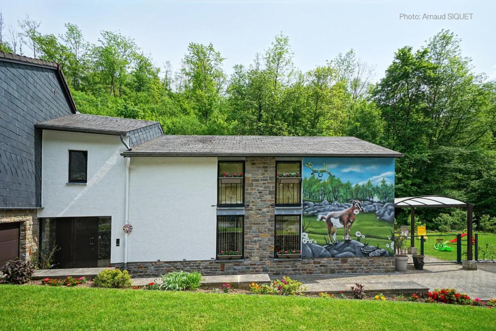 a house with a mural on the side of it at Gîte les gadlis in Aywaille