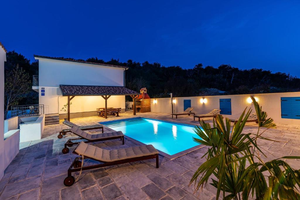 a villa with a swimming pool at night at Vitez's House Novigrad/Knight's House Novigrad in Novigrad Dalmatia