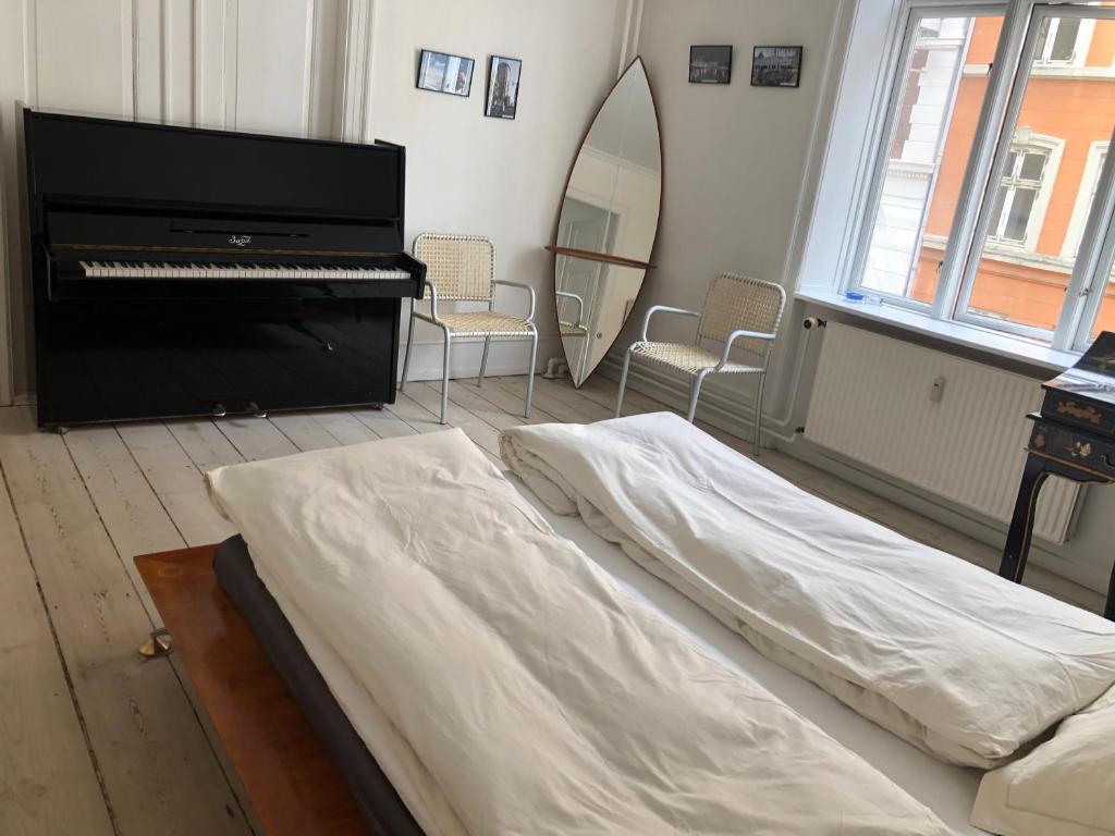 a bedroom with a bed and a piano at Outhentic Apartment in Copenhagen
