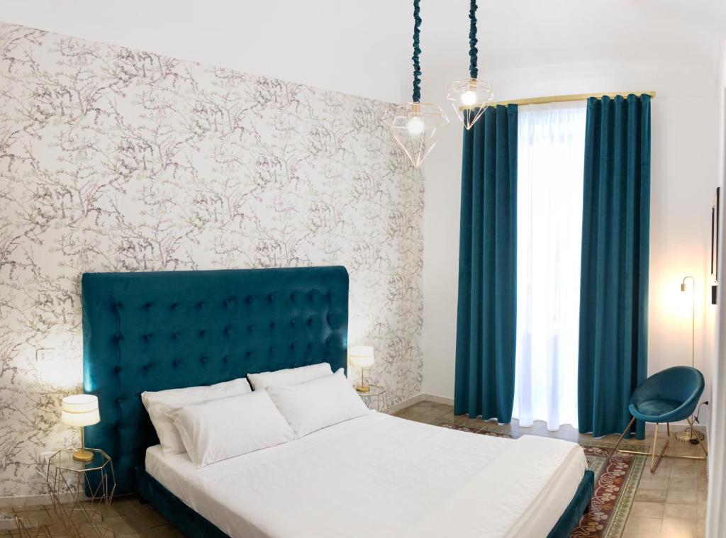 a bedroom with a bed with a blue headboard at Liberty house in Siracusa