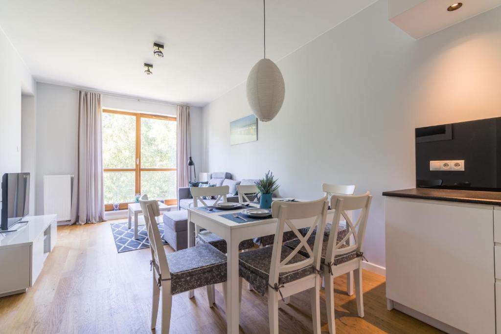 - une cuisine et une salle à manger avec une table et des chaises dans l'établissement Nadmorski, à Gdańsk