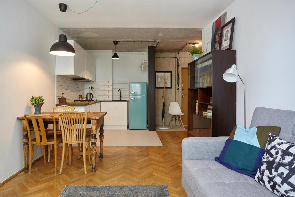 een woonkamer en een keuken met een tafel en een bank bij Apartament - Stara Ochota in Warschau