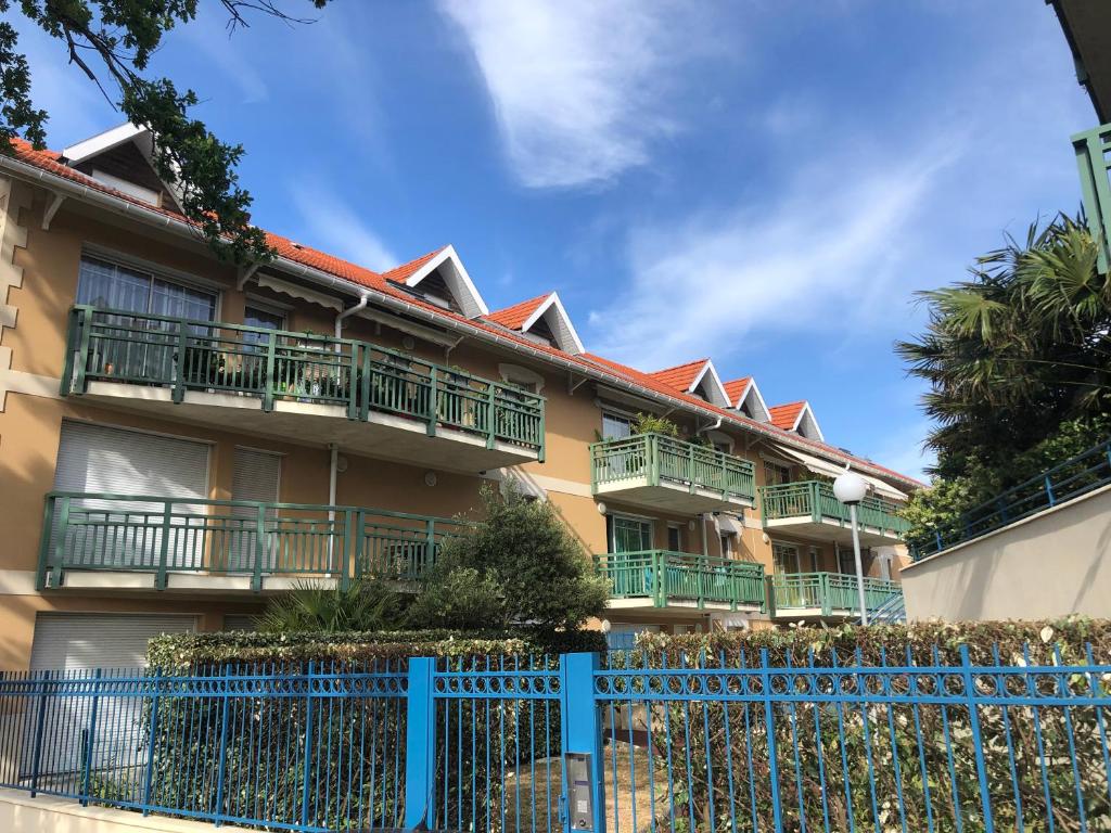 a building with balconies and a blue fence at ARCACHON appartement T2 51M2 et parking privatif en sous sol in Arcachon