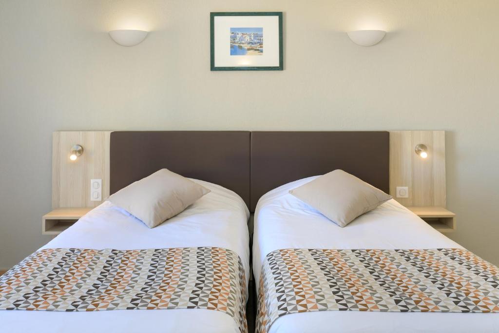two beds sitting next to each other in a room at Joseph Charles in LʼÎle-Rousse