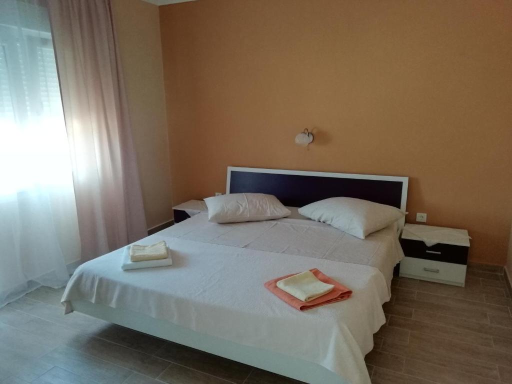 una camera da letto con un letto bianco con due asciugamani di Feel Good Apartment a Mundanije