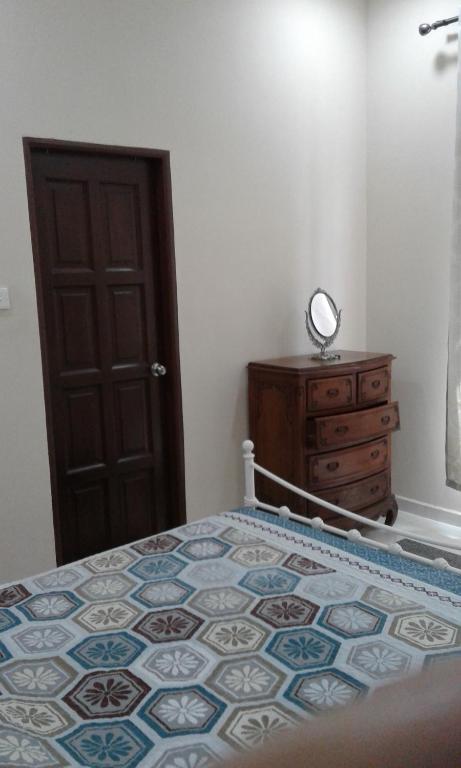 um quarto com uma cama e uma cómoda em madeira em Rose Guest House em Kota Bharu